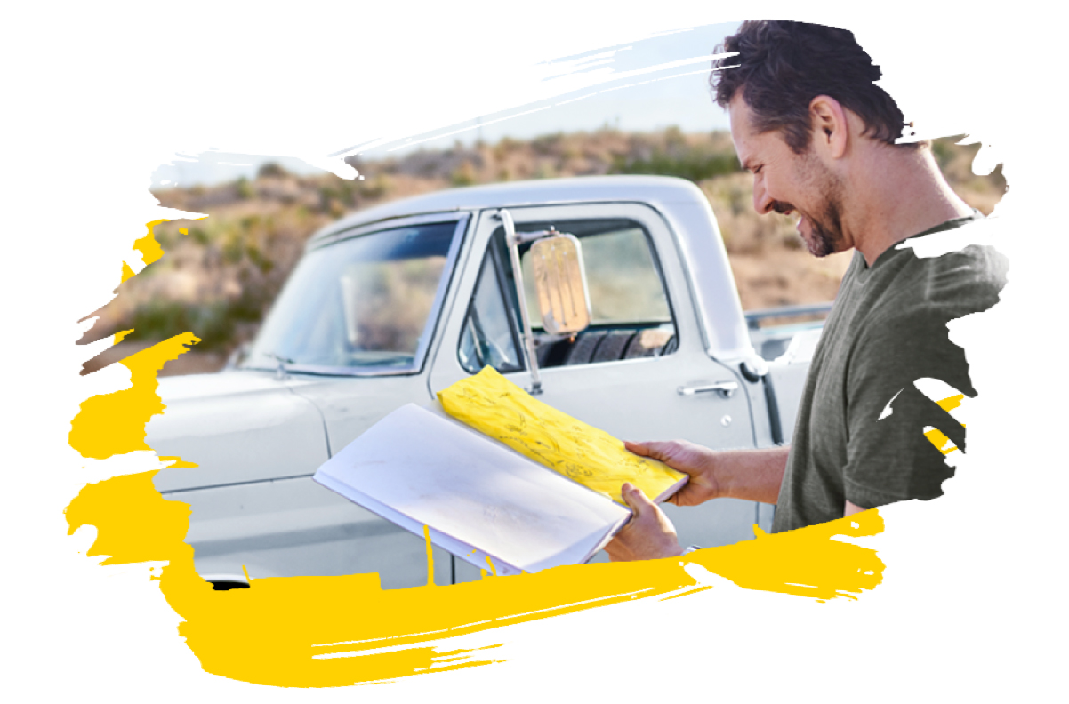 Man reading his map while standing outside next to his car
