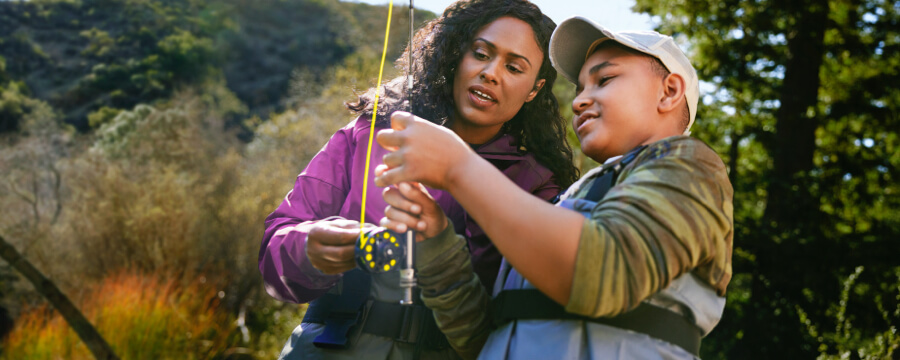 A woman fishing with a boy.
